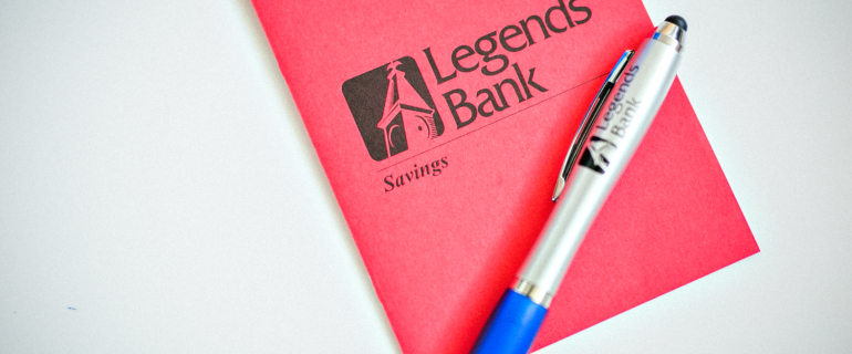 A photo of a Legends Bank Savings booklet and pen.
