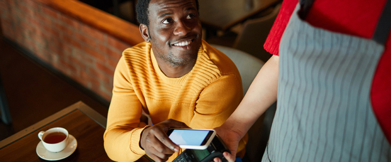 Man using phone to pay at a restaurant